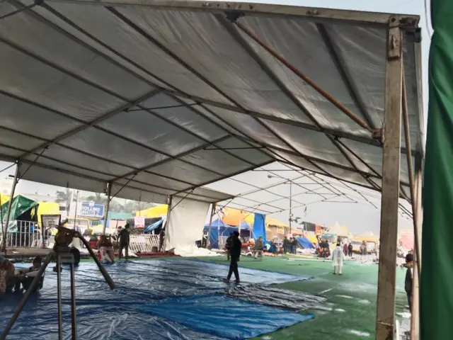 सिंघु बॉर्डर पर वॉटरप्रूफ टेंट लगाते लोग