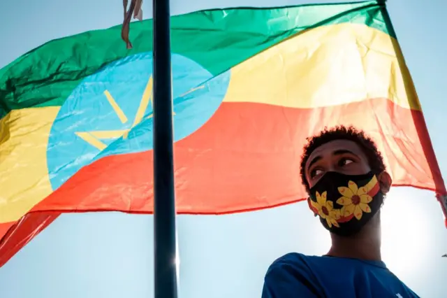 የኢትዮጵያን ሰንደቅ ዓላማ የያዘ ወጣት