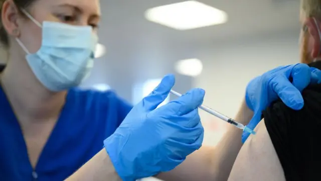 ممرضة تعطي رجلاً جرعة من اللقاح المضاد لفيروس كورونا