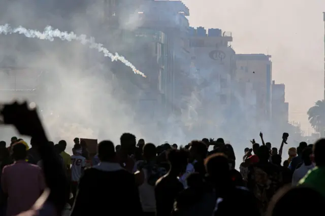 الغاز المسيل للدموع يملئ الأجواء خلال مظاهرة في الخرطوم، وفي الصورة تظهر قنبلة مسيلة للدموع تُلقى على المتظاهرين