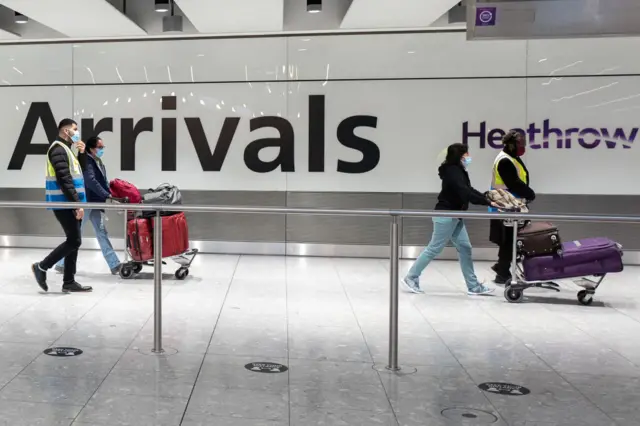 Nhân viên sân bay hộ tống hành khách tới Londn Heathrow làm thủ tục nhập cảnh và cách ly