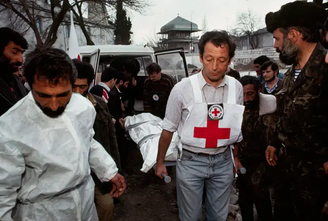 Beynəlxalq Qızıl Xaç Cəmiyyətinin işçiləri Xocalıda həlak olanların meyitlərini Ağdamdakı morqa daşıyır. Fevral, 1992.