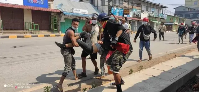 ဒဏ်ရာရသွားတဲ့ဆန္ဒပြလူငယ်အမျိုးသားတစ်ဦးကို အခြားလူတွေက ဝိုင်းသယ်လာကြပုံ