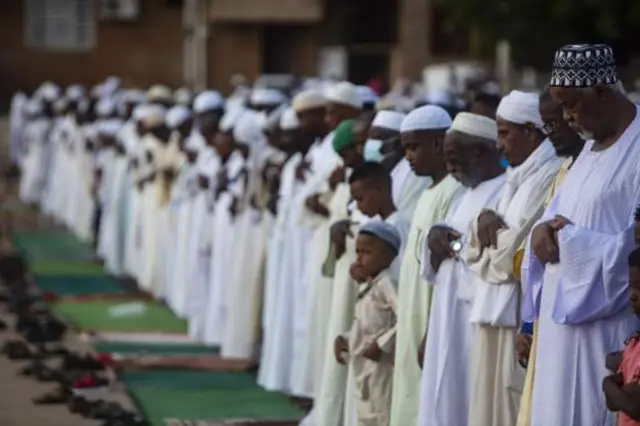 The congregation stands in prayer in al-Farah Square in Sudan's capital, Khartoum