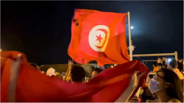 متظاهرون في تونس يرفعون العلم