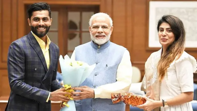 रविंद्र जडेजा और उनकी पत्नी रिवाबा जडेजा पीएम मोदी के साथ