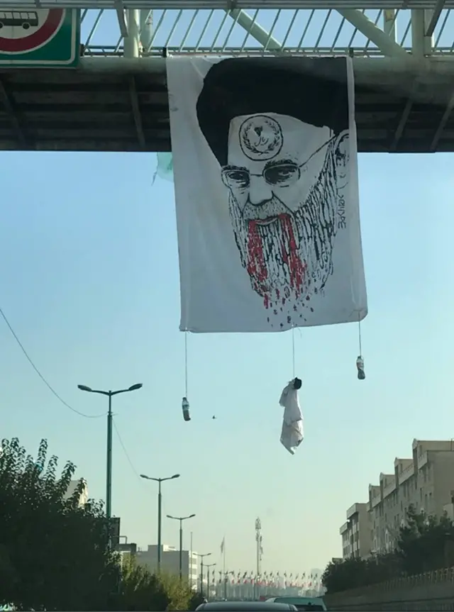تصویر علی خامنه‌ای با نشان یک دوزاری بر پیشانی‌اش
