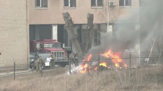 Uniformed people are seen throwing items into a fire outside intelligence building on the premises of the Ukrainian Defence Ministry"s unit, in Kyiv, Ukraine February 24, 2022