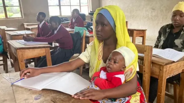 Mwanafunzi mzazi akiwa na mtoto wake darasani