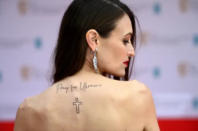 Одна з учасниць церемонії прийшла з надписом на спині "Моліться за Україну"