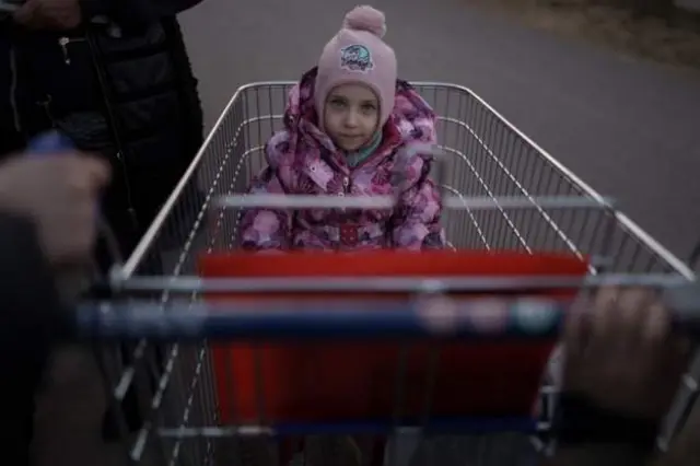 One refugee girl wey dey escapre Ukraine war inside supermarket trolley