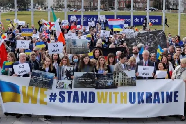In Strasbourg, members of the Parliamentary Assembly of the Council of Europe show their support for Ukraine, ahead of a video address by President Zelensky