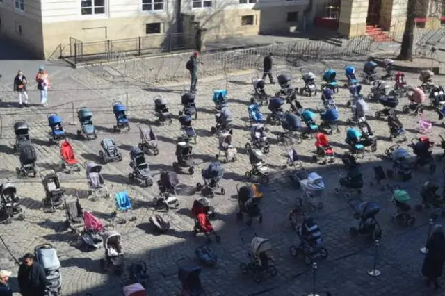 Foto of baby strollers wey symbolise di war child victims for Ukraine