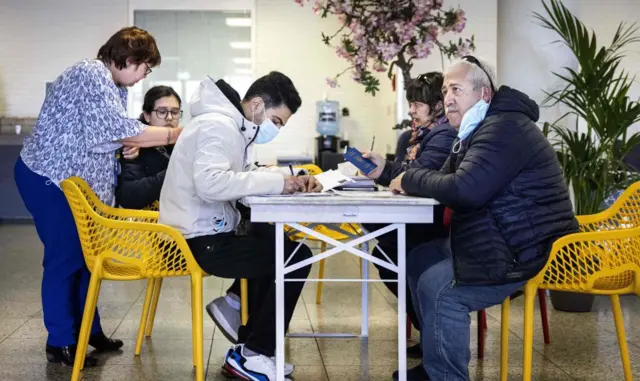 Hollanda'daki kayıt merkezinde başvuru belgelerini dolduran bir Ukraynalı sığınmacı