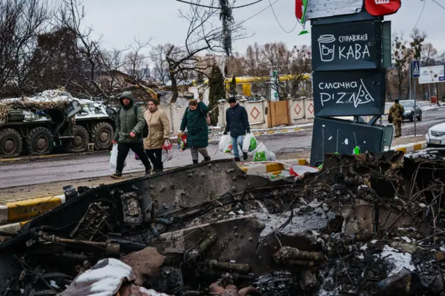 Місцеві мешканці обходять залишки російської військової колони у Бучі