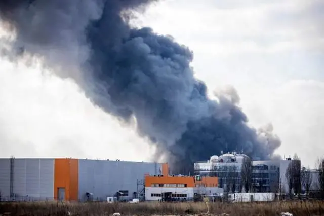 Smoke rising from a burning warehouse hit by a Russian shell in the suburbs of Kyiv.