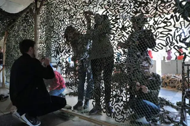 Ukrainian volunteers make camouflage nets for the Ukrainian army to counter the Russian military invasion