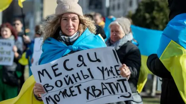 Wannan matar tana rike da kwalin da ke cewa yakin wata daya ya isa inda suka tsaya a Ofishin Jakdancin Rasha da ke Chisinau, Moldova