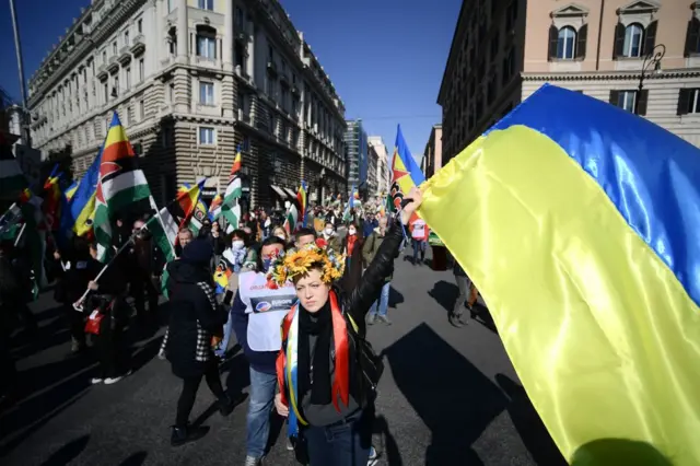 ਰੋਮ ਵਿੱਚ ਇੱਕ ਔਰਤ ਯੂਕਰੇਨ ਦਾ ਝੰਡਾ ਚੁੱਕ ਕੇ ਰੂਸੀ ਹਮਲੇ ਦੇ ਵਿਰੋਧ ਵਿੱਚ ਕੱਢੇ ਮਾਰਚ ਵਿੱਚ ਸ਼ਾਮਲ ਹੁੰਦੀ ਹੋਈ