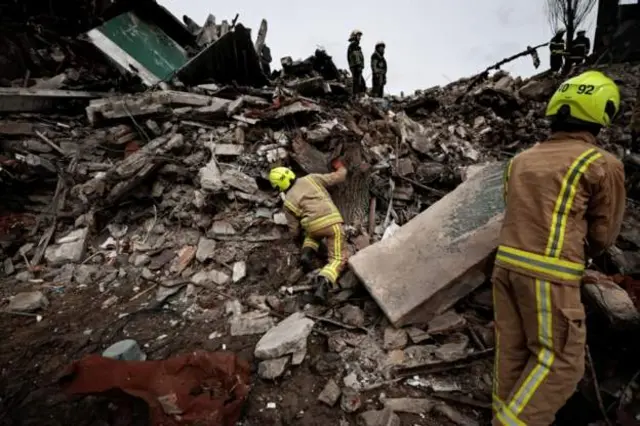 Rescuers search for bodies in the rubble of a residential building destroyed by Russian shelling in Borodyanka