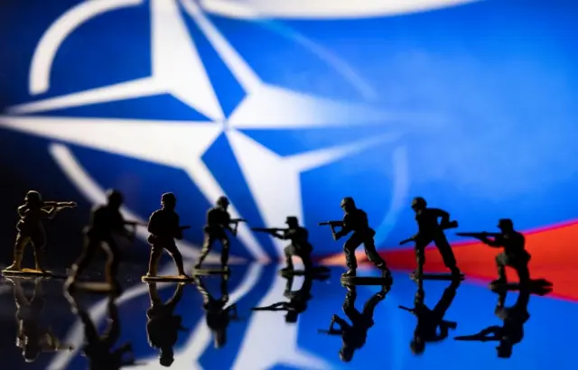 НАТО ва Россия байроқлари фонида ўйинчоқ аскарлар