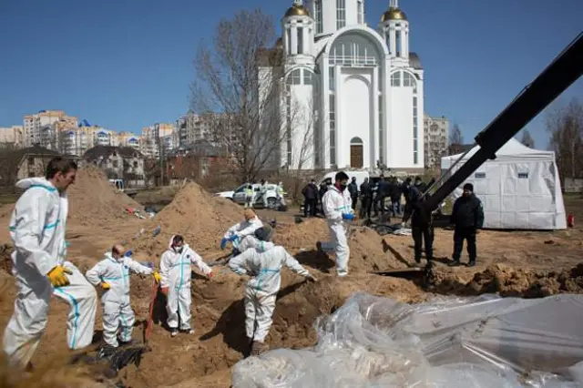 Masu tono gawawwaki suna aikinsu a wani babban kabari a Bucha, Ukraine ranar 14 ga watan Afrilun 2022. Rasha ta janye daga wasu garuruwan Ukraine scores of civilian deaths.