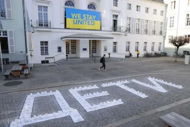 Deutsches Theater Shows Solidarity With Ukraine BERLIN, GERMANY - MARCH 29: The Ukrainian word for children, "dyeti," lies painted on cobblestones outside the Deutsches Theater as a Ukrainian flag bearing the inscription "We Stand United" hangs above the entrance on March 29, 2022 in Berlin, Germany. The theatre is showing its solidarity with war-torn Ukraine, and in particular with the Donetsk Regional Drama Theatre in Mariupol that was sheltering 1,300 civilians and was bombed by Russian military forces, despite the similar inscription of "dyeti" painted in very large letters on the ground on two sides of the theatre.
