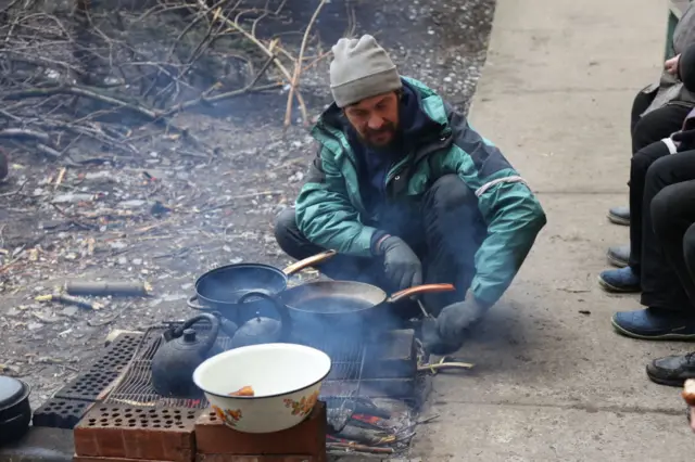 Житель Мариуполя готовят еду на костре