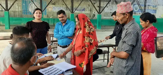 बुटवल उपमहानगरपालिका– ५, स्थित मतदान केन्द्रमा खटिएका कर्मचारी मतदानका लागि परिचयपत्र वितरण गर्दै