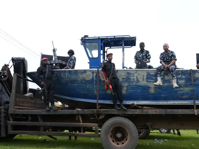 Police officers sit ontop boat