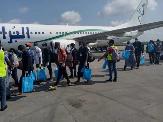 returnees dey line up to enta plane