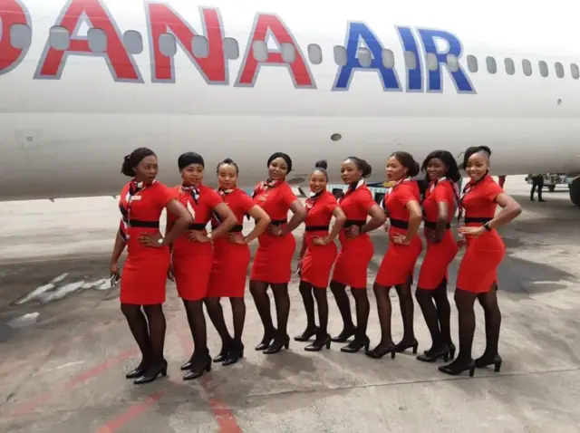 Dana Air staff stand beside dia plane
