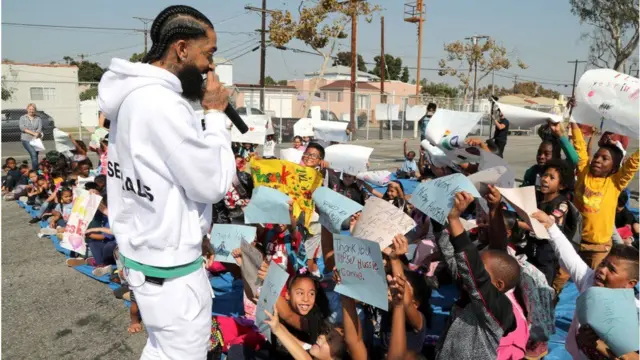 Late Nipsey Hussle dey tok to pikins wey gada wit placard for dia hands