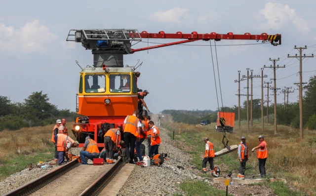 Рабочие чинят железнодорожные пути