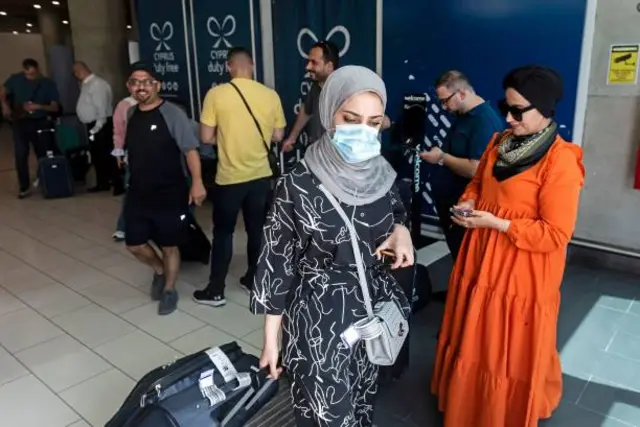فلسطينيون يغادرون مطار لارنكا الذي وصلوا إليه على متن أول رحلة تقل فلسطينيين من مطار رامون يوم 22 أغسطس/آب