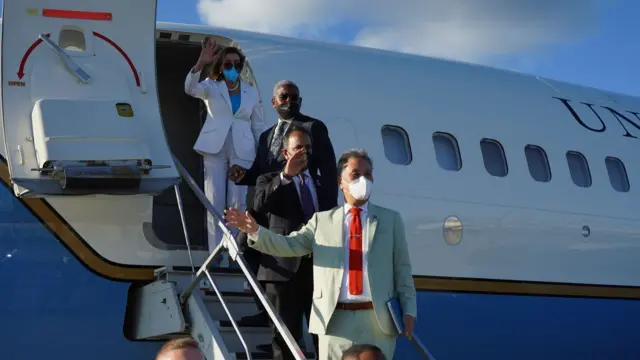 佩洛西（上）一行在台北松山机场登上美军专机时向送行人员挥手道别（3/8/2022）