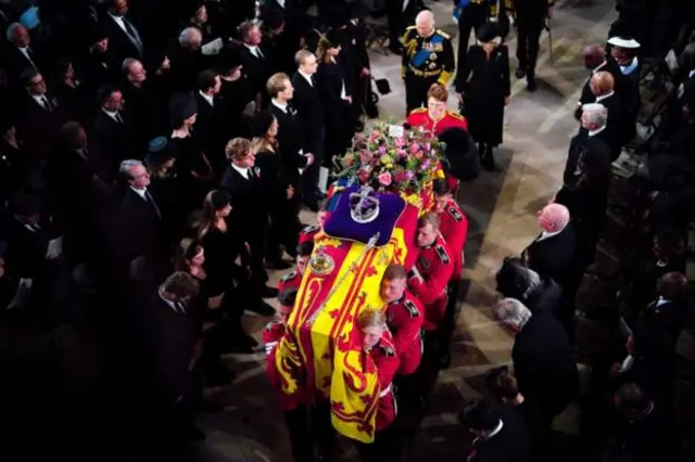The pall bearers carry the Queen's coffin into the chapel and down the nave