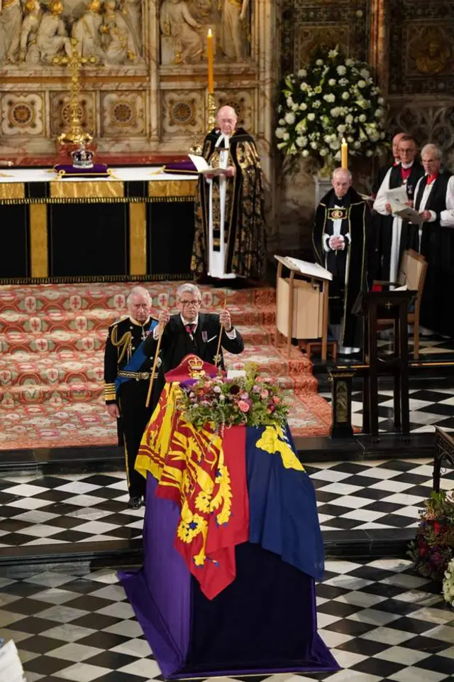 The Lord Chamberlain ceremonially breaks his wand of office and places it on the coffin