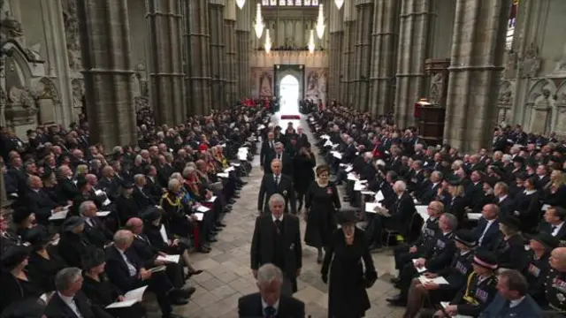 A procession of prime ministers wey serve during di Queen's reign walk up di Abbey
