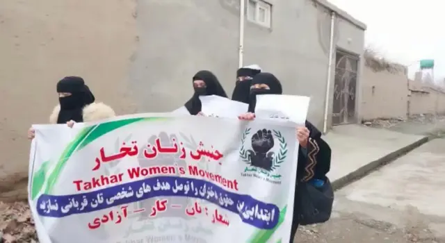 زنان در تخار که پلاکاردی در دست دارند