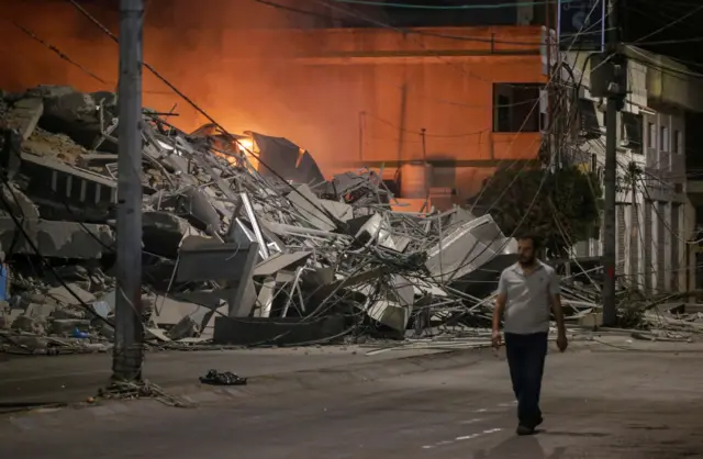 رجل فلسطيني يسير بجوار آثار غارة جوية إسرائيلية على مدينة غزة، 09 أكتوبر 2023.
