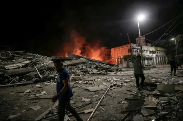 رجل فلسطيني يسير بجوار آثار غارة جوية إسرائيلية على مدينة غزة، 09 أكتوبر 2023.