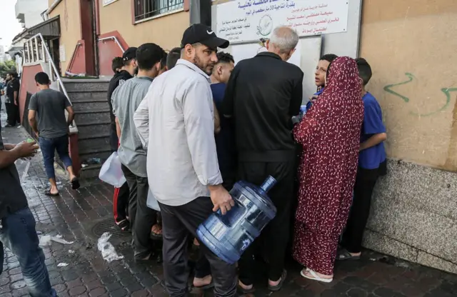 سكان مدينة غزة يحملون عبوات المياه مع بدء الإخلاء