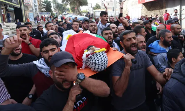 مشيعون يحضرون جنازة فلسطينيين اثنين في مدينة رام الله بالضفة الغربية