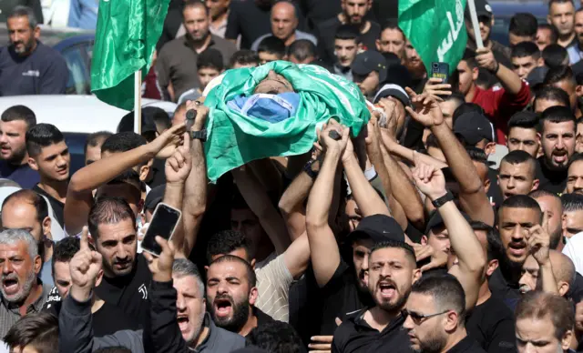 مشيعون فلسطينيون جنازة شاب، أمس، بالقرب من مدينة نابلس بالضفة الغربية المحتلة
