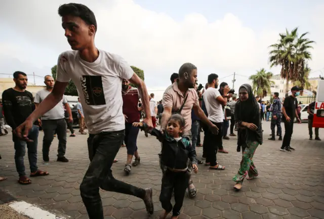 رجل يهرب بطفلته من القصف