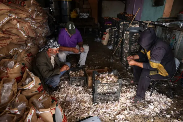 इसराइल-हमास संघर्ष के बीच ग़ज़ा में विस्थापित हुए परिवारों के लिए खाना बनाते लोग