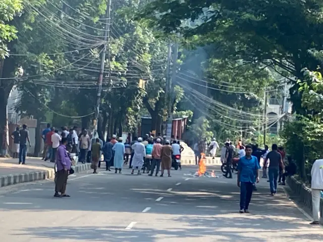 রাস্তায় আগুন জ্বলতে দেখা যাচ্ছে