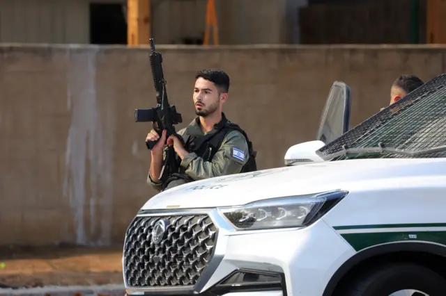 أحد أفراد الشرطة الإسرائيلية يقف في أحد الشوارع بعد إطلاق صواريخ من غزة في عسقلان، 07 أكتوبر/تشرين الأول 2023.