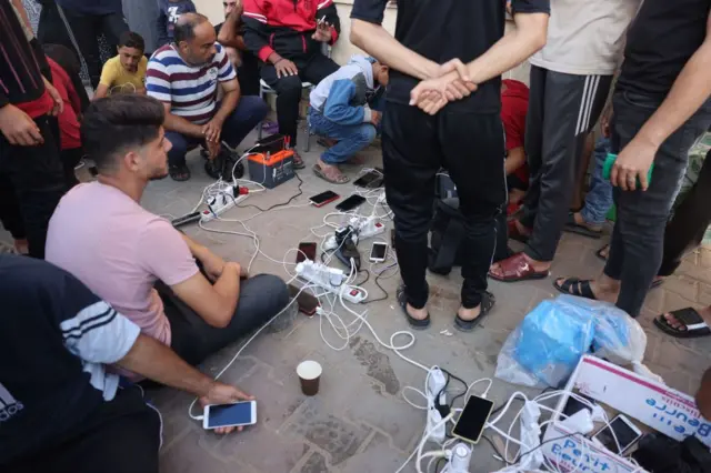 نقطة جماعية لشحن الهواتف في أحد مراكز الإيواء في جنوب قطاع غزة، وسط تكثيف شديد للقصف الإٍسرائيلي